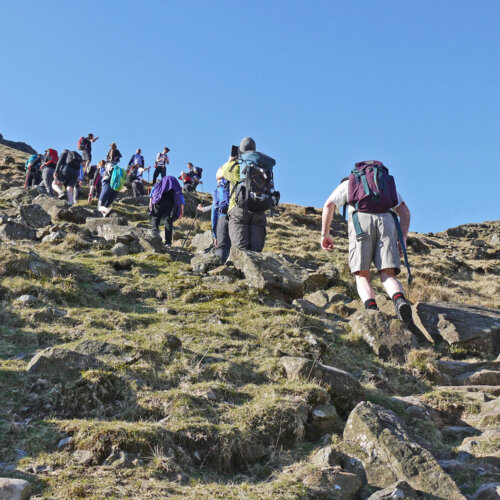 Lake District Triple Challenge - Image of walkers following a path up a mountain