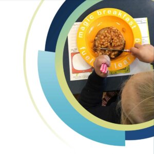 child eating baked beans at magic breakfast club