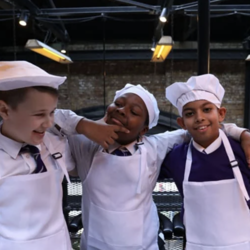 three children laughing with chefs outifts