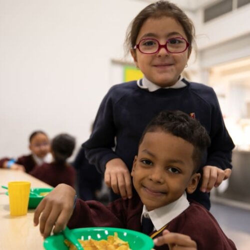 A primary school boy and girl enjoying cereal for breakfast at school