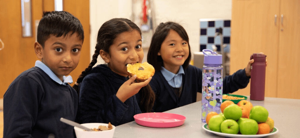 Three children enjoying Magic Breakfast at school