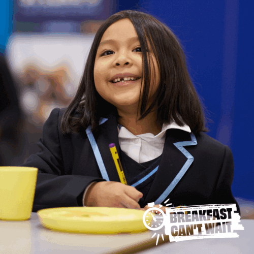 School girl eating breakfast in school uniform