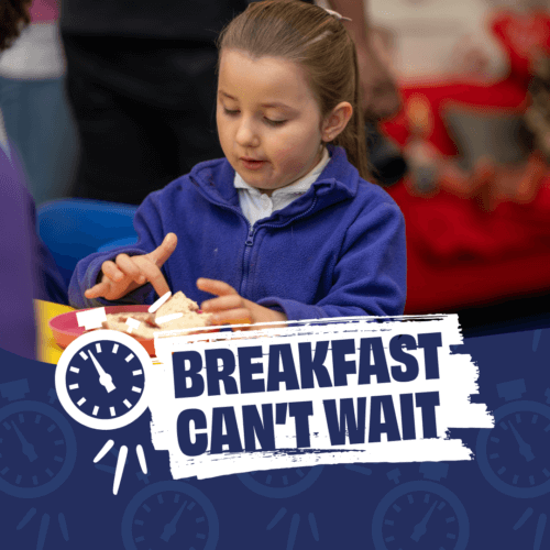 Image of a child eating breakfast, with the title of Magic Breakfast's campaign in Scotland, Breakfast Can't Wait.