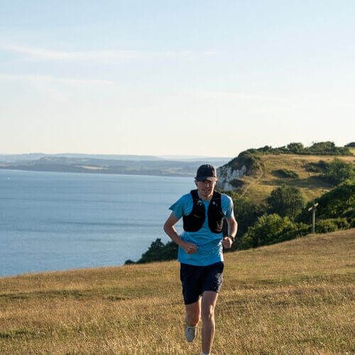 Image from Oppidan School run of an individual running on a coastal path.
