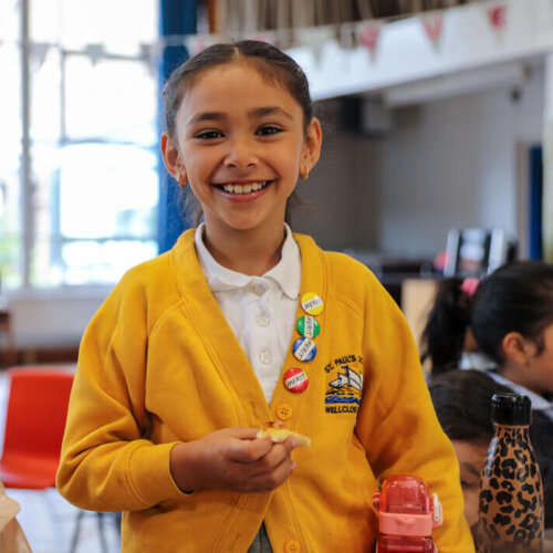 Primary school child smiling as they walk around at school breakfast club