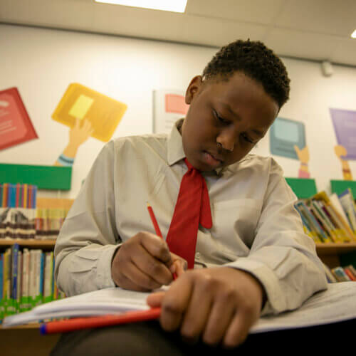 A young student writes in his exam revision book