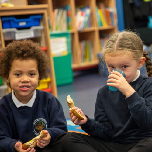Imagine of three children eating breakfast at school.