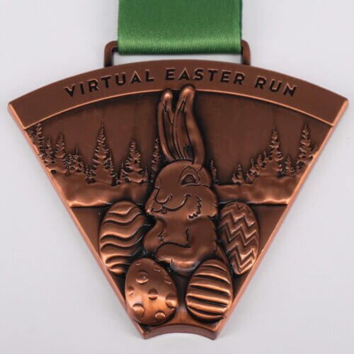 A bronze medal of the Virtual Easter Run, with rabbit and easter eggs in a wood engraved into medal.